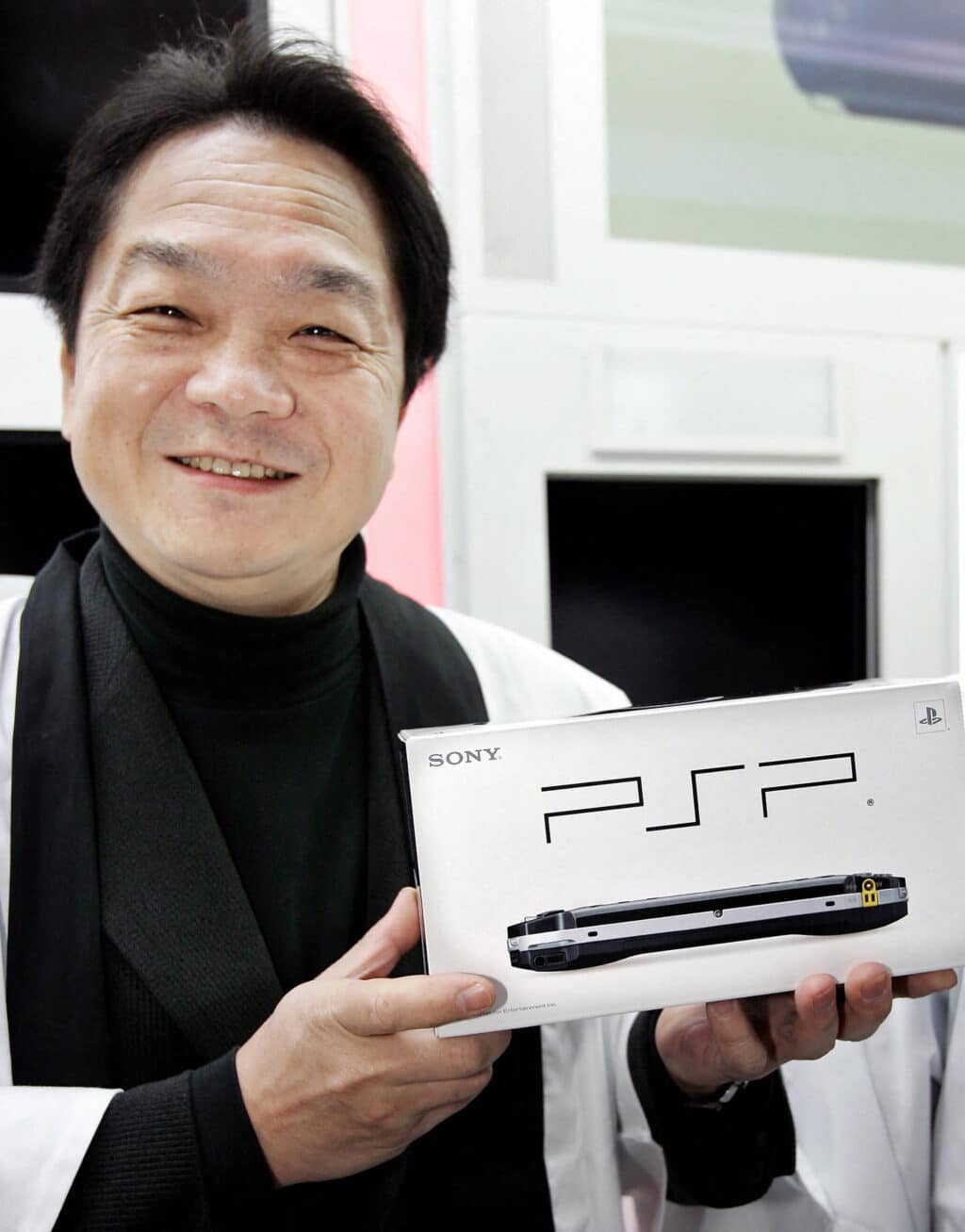 (FILES) Sony Computer Entertainment president Ken Kutaragi poses with the new handheld video game console PlayStation Portable (PSP) at a Tokyo electrics shop on December 12, 2004.| Photo by YOSHIKAZU TSUNO / AFP