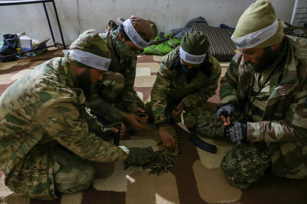 Anti regime fighters load magazines with ammunition as they prepare for battle in the northern Syrian city of Idlib on November 28, 2024. | Photo by Omar HAJ KADOUR / AFP