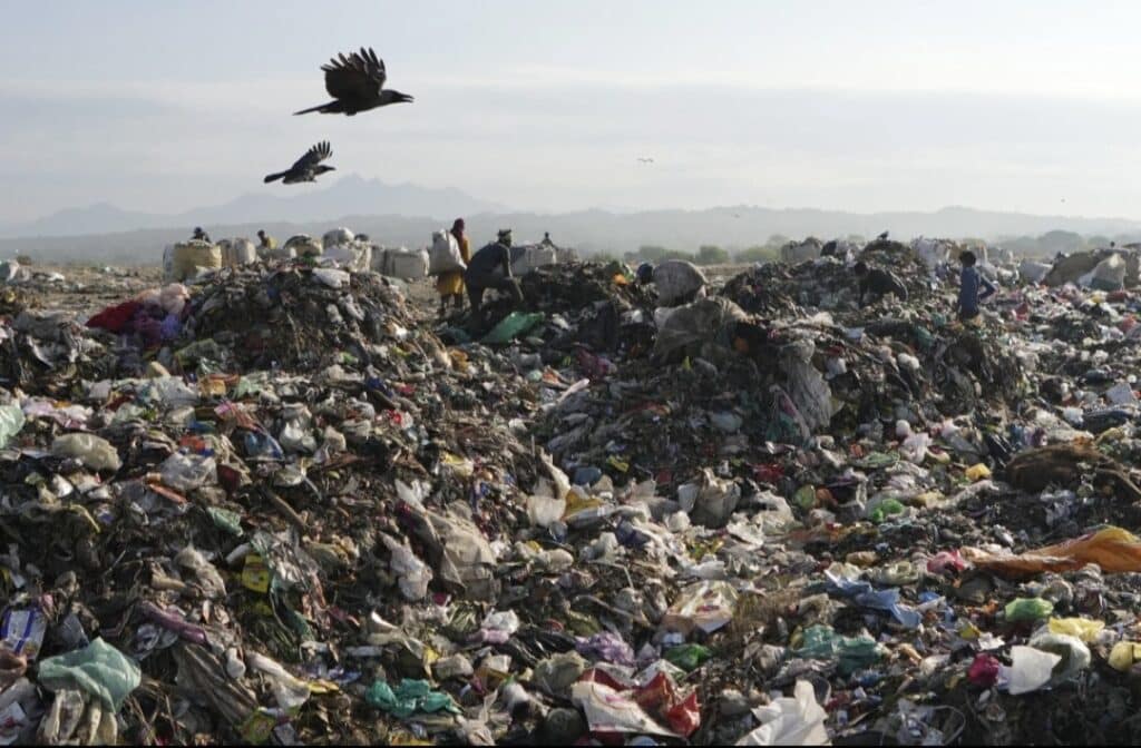 FILE - Indian rag pickers look for reusable material at a garbage dump filled with plastic and other waste material on the outskirts of Jammu, India, April 22, 2024