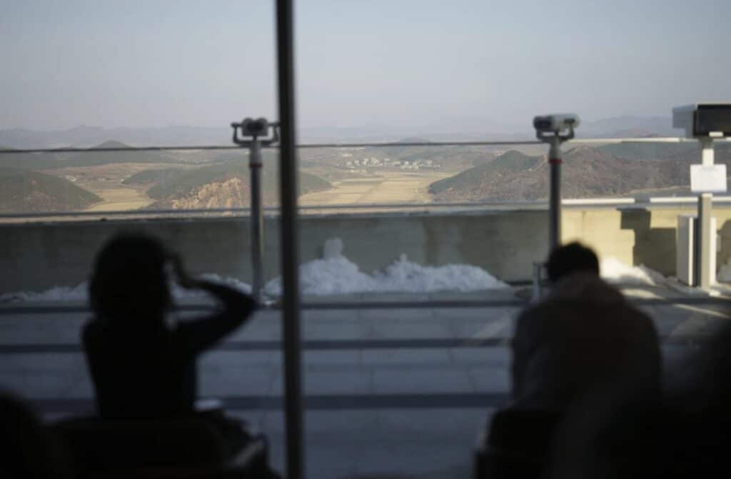 Visitors sit at newly opened Starbucks store asNorth Korea's Kaephung county is seen on background at the observatory of the Aegibong Peace Ecopark in Gimpo, South Korea, Friday Nov. 29, 2024.