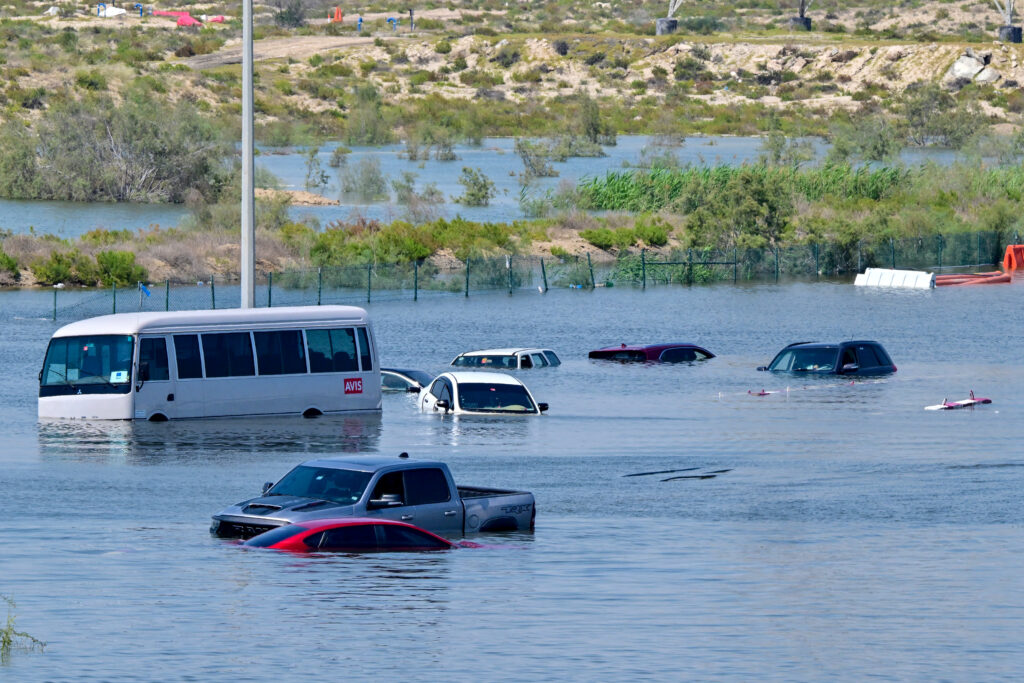 Climate change spurs disaster in 2024: 'Dangerous new era'. Cars are stranded on a flooded street in Dubai following heavy rains on April 18, 2024. Dubai's giant highways were clogged by flooding and its major airport was in chaos as the Middle East financial centre remained gridlocked on April 18, a day after the heaviest rains on record. (Photo by Giuseppe CACACE / AFP)