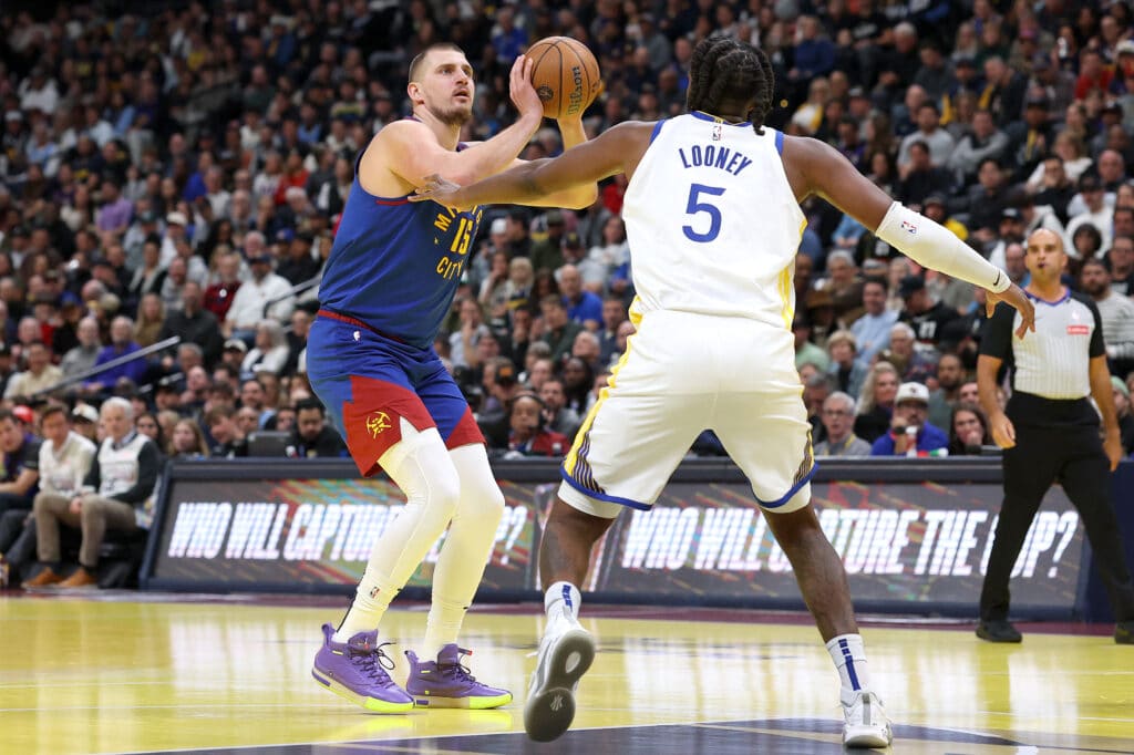 NBA: Nuggets mount late comeback to beat Warriors. In photo is Nikola Jokic #15 of the Denver Nuggets putting up a shot against Kevon Looney #5 of the Golden State Warriors in the first quarter of the Emirates NBA Cup at Ball Arena on December 3, 2024 in Denver, Colorado. | Photo by Matthew Stockman/Getty Images via AFP