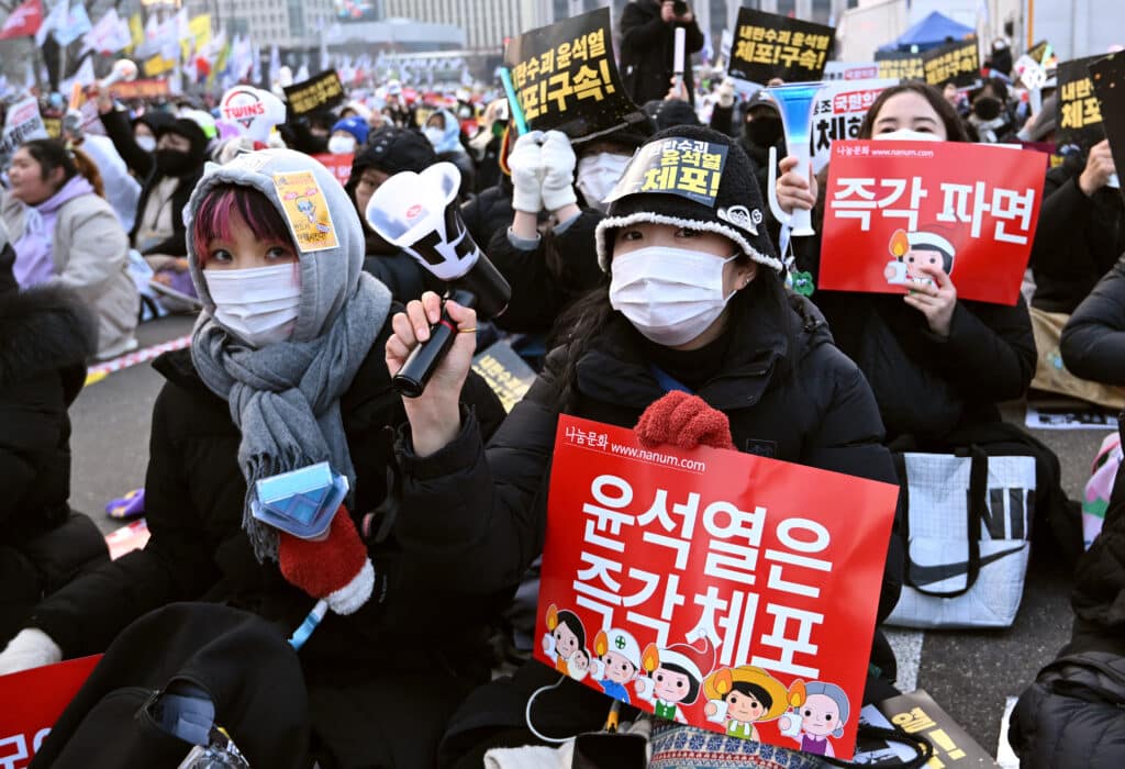 Protesters hold placards reading "Arrest Yoon Suk Yeol immediately" during a rally calling for the ouster of South Korea's impeached President Yoon Suk Yeol in front of the Gwanghwamun Gate of Gyeongbokgung Palace in Seoul on December 21, 2024. (Photo by Jung Yeon-je / AFP)