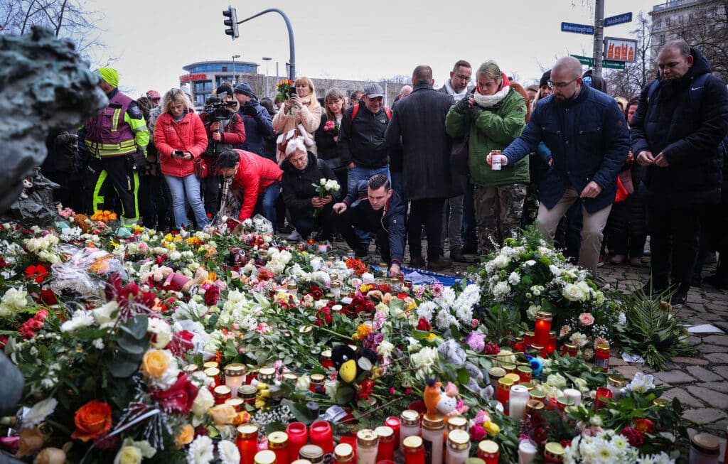 Christmas market attack: Sorrow and fury in German town. Well wishers lay flowers near the site of a car-ramming attack on a Christmas market in Magdeburg, eastern Germany, on December 21, 2024, resulting in several deaths and dozens of injured. | Photo by Ronny HARTMANN / AFP