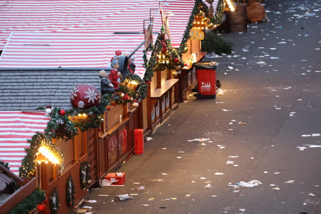 Christmas market attack: Sorrow and fury in German town. Debris and closed stalls are seen on a Christmas market one day after a car-ramming attack in Magdeburg, eastern Germany, on December 21, 2024, resulting in several deaths and dozens of injured. | Photo by Ronny HARTMANN / AFP