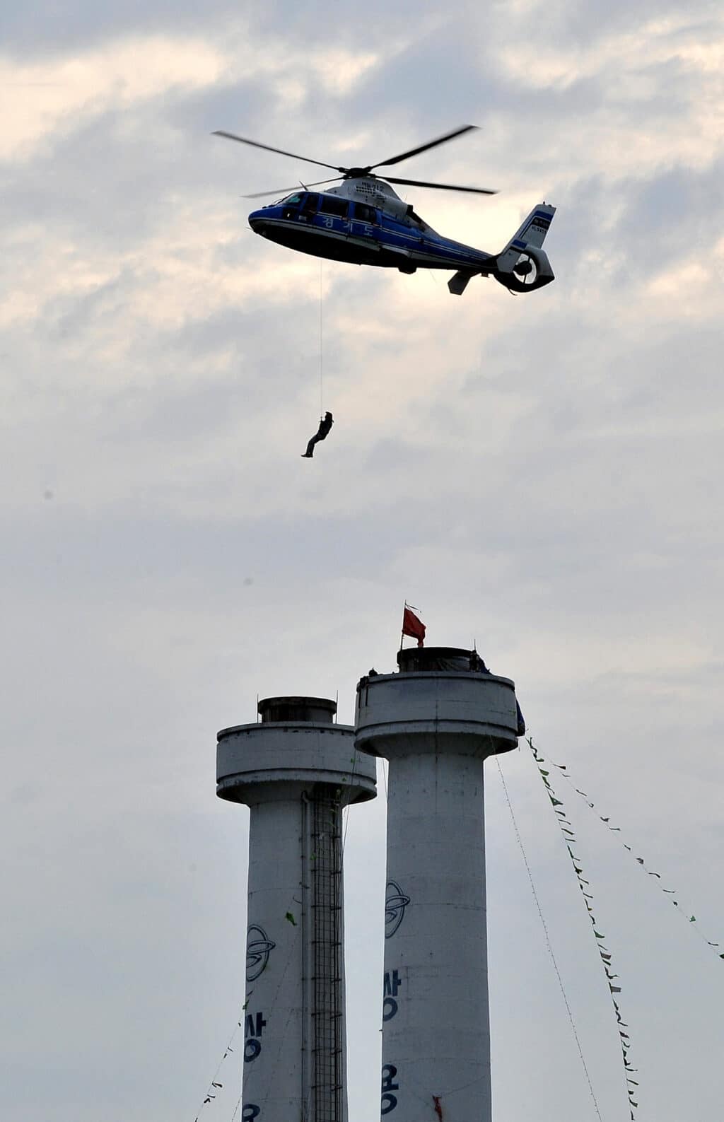 ‘Squid Game’: Real-life violence that inspired South Korean show. (FILES) A helicopter rescues a striking worker from a tower after unionists and management agreed to end the sit-in at Ssangyong Motor in Pyeongtaek, 70km south of Seoul, on August 6, 2009. | Photo by JUNG YEON-JE / AFP