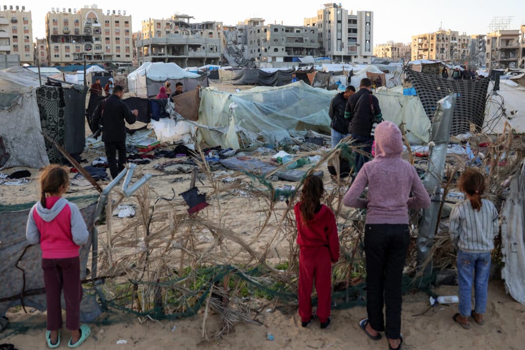 People inspect the site of reported Israeli bombardment on tents sheltering Palestinians displaced from Beit Lahia at a camp in Khan Yunis in the southern Gaza Strip on December 25, 2024 amid the ongoing war in the Palestinian territory between Israel and Hamas. (Photo by BASHAR TALEB / AFP)