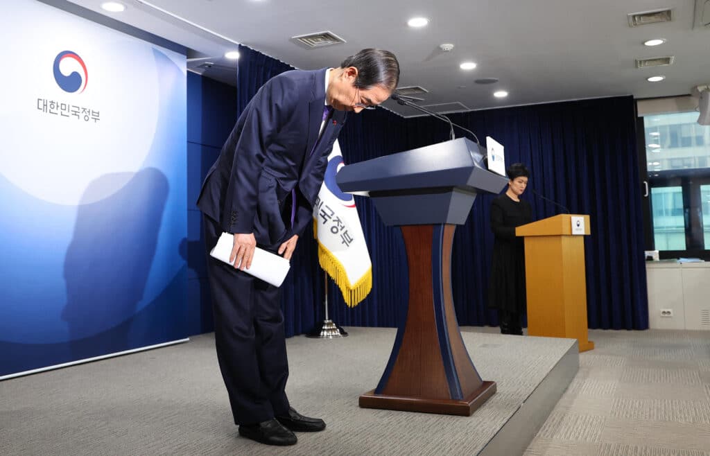 South Korea Prime Minister and acting President Han Duck-soo bows as he delivers his address to the nation at the Government Complex in Seoul on December 26, 2024. | Photo by YONHAP / AFP