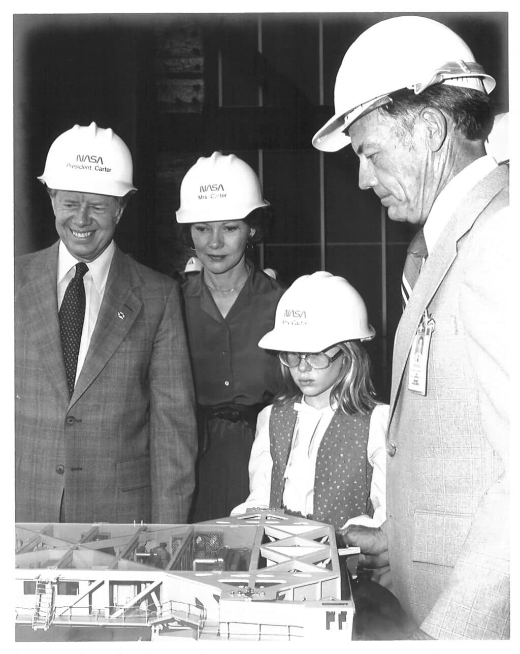 This handout image released by NASA on December 29, 2024 shows President Carter, wife Rosalynn and daughter Amy are shown a scale model of the crawler that transported the total shuttle launch configuration to Pad 39 from the Vehicle Assembly Building by NASAs Kennedy Space Center Director Lee Scherer in 1978. | Photo by NASA / AFP