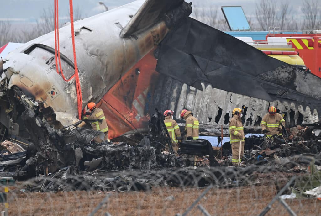 Firefighters and recovery teams work at the scene where a Jeju Air Boeing 737-800 series aircraft crashed and burst into flames at Muan International Airport in Muan, some 288 kilometres southwest of Seoul on December 30, 2024. | Photo by JUNG YEON-JE / AFP