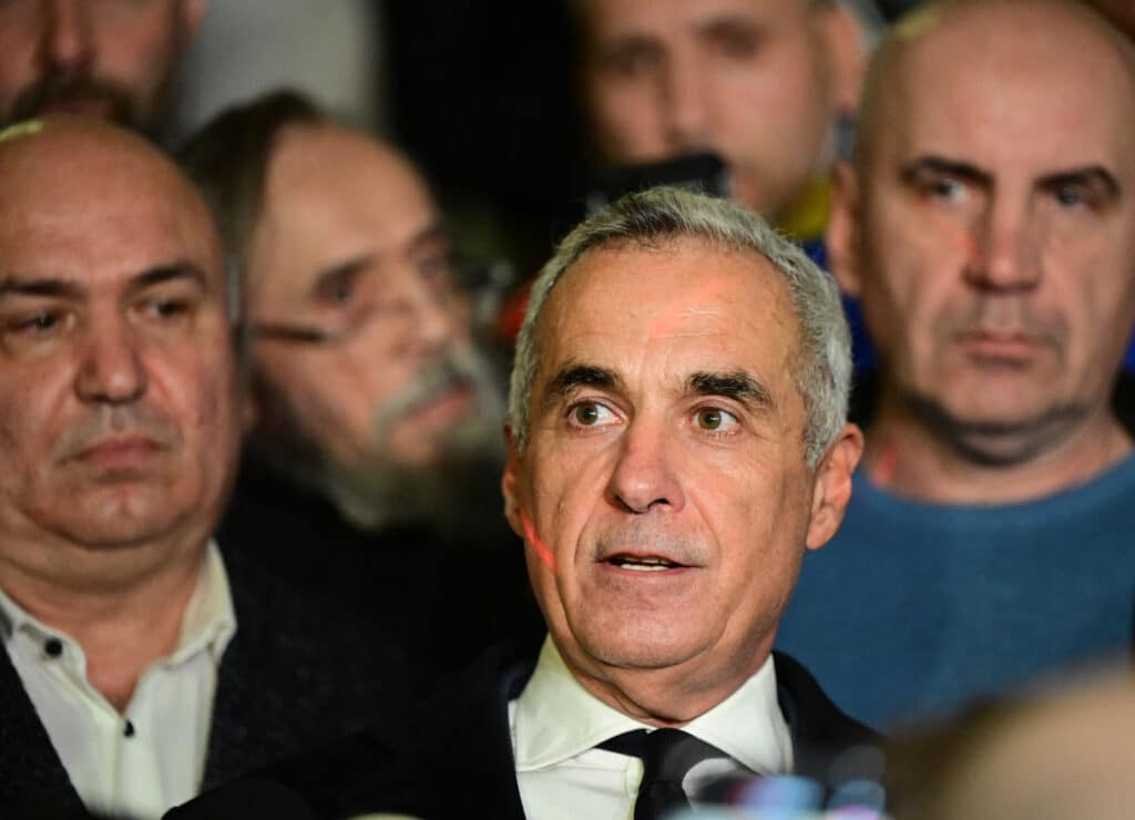 Romanian former presidential candidate Calin Georgescu (R) addresses the media inside The Court of Appeal in Bucharest on December 30, 2024. | Photo by Daniel MIHAILESCU / AFP