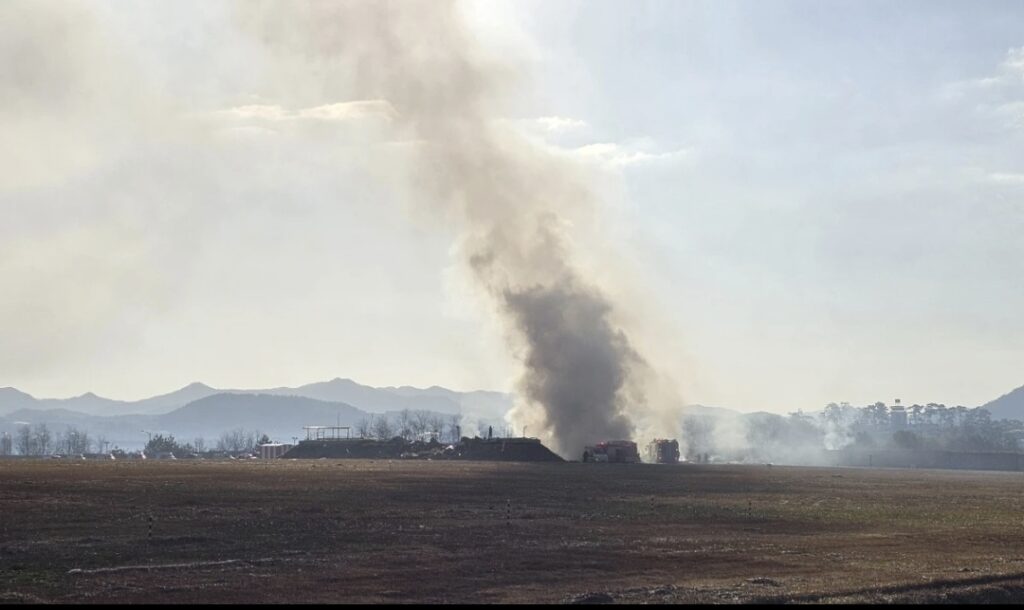 Firefighters work to extinguish a fire off the runway of Muan International Airport in Muan, South Korea, Sunday, Dec. 29, 2024. (Maeng Dae- hwan/Newsis via AP)