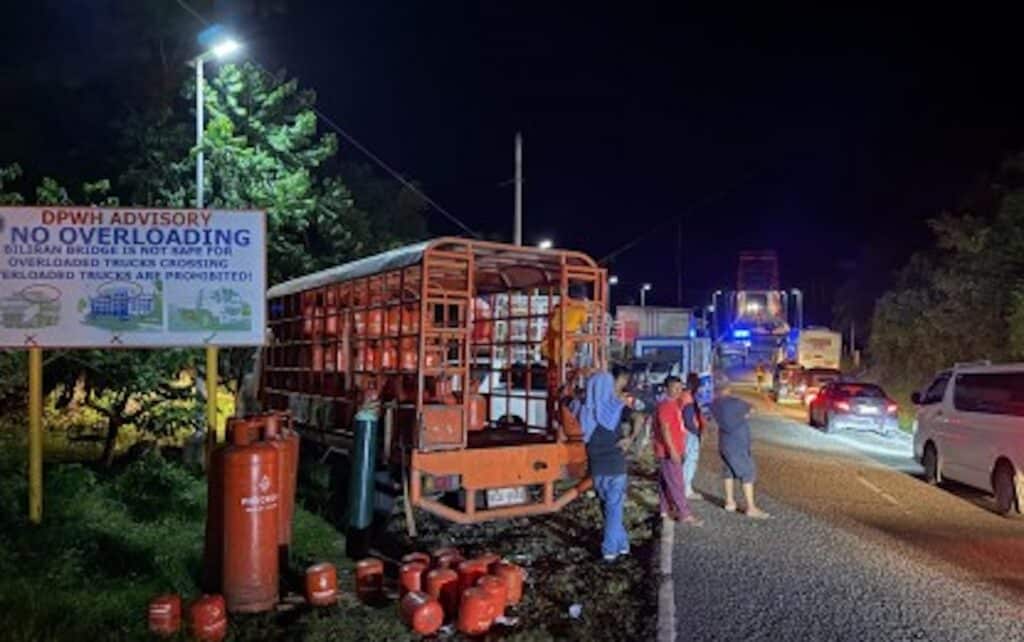 LIMITED. Truckers unload some of their cargoes in compliance with the load limit imposed by the Department of Public Works and Highways for the Biliran Bridge. (Photo courtesy of Biliran Island)