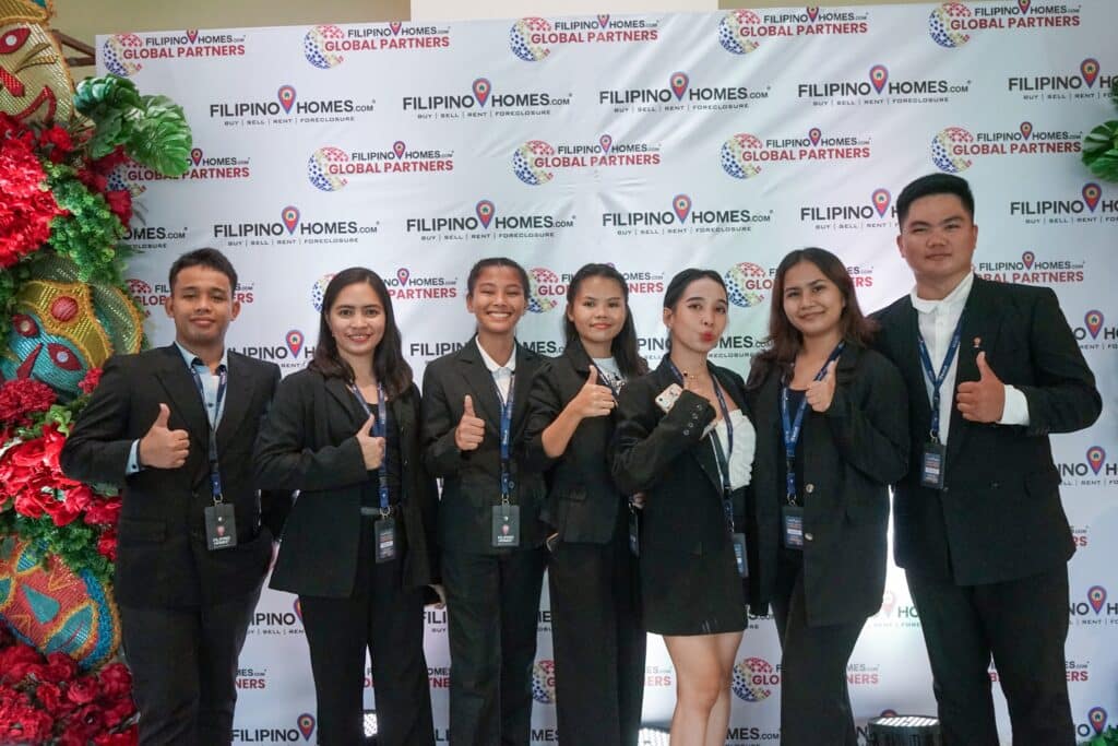 Real estate professionals pose in front of Filipino Homes' backdrop during the Jumpstart Training