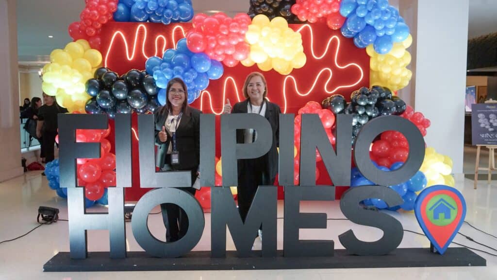 Guests at Filipino Homes' Jumpstart Training poses in front of a decorative set up