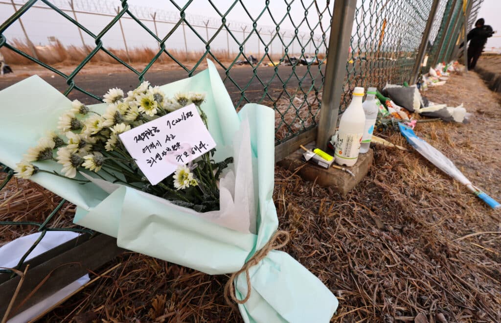 Tributes are placed along a fence near the site where a Jeju Air Boeing 737-800 aircraft crashed and burst into flames at Muan International Airport in Muan, some 288 kilometres southwest of Seoul on January 2, 2025. | Photo by YONHAP / AFP