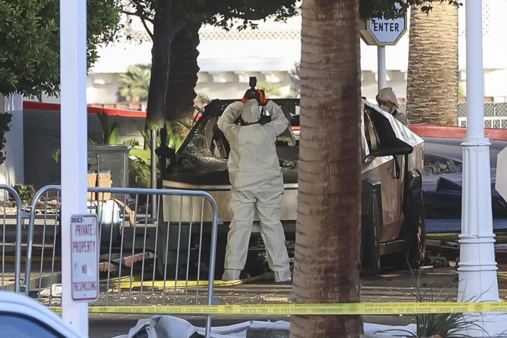 Vegas Tesla blast suspect shot himself before explosion - officials. Photo shows an investigator photographing a Tesla Cybertruck that exploded outside the lobby of President-elect Donald Trump's hotel on January 1, 2025, in Las Vegas. | Photo by WADE VANDERVORT / AFP