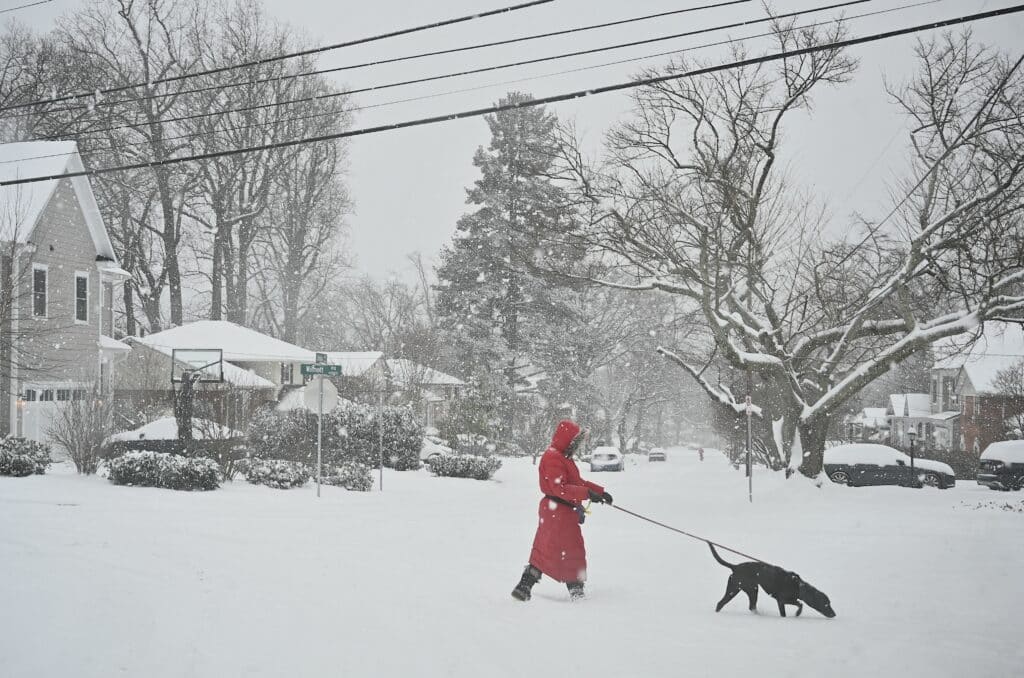 Polar vortex keeps much of the US in its icy grip. A pedestrian crosses the street as snow falls during a winter storm in Bethesda, Maryland on January 6, 2025. | Photo by PEDRO UGARTE / AFP