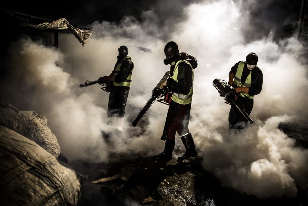 (FILES) Members of a privately-funded NGO working with county officials wearing protective gear fumigate and disinfect on April 15, 2020, during the dusk-to-dawn curfew imposed by the Kenyan Government, the streets and the stalls at Parklands City Park Market in Nairobi to help curb the spread of the COVID-19 coronavirus. - Five years since Covid-19 started upending the world, the virus is still infecting and killing people across the globe -- though at far lower levels than during the height of the pandemic. Here is the current state of the play. (Photo by LUIS TATO / AFP)