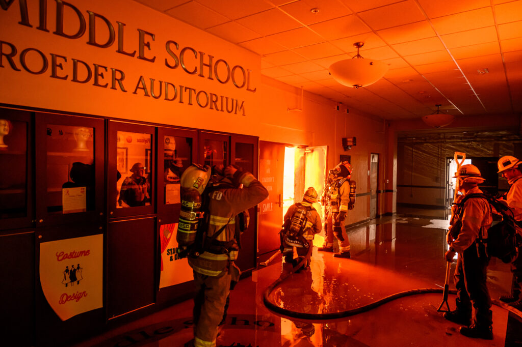 Firefighters prepare to fight flames from inside Eliot Arts Magnet Middle School auditorium as the school burns during the Eaton fire in the Altadena area of Los Angeles county, California on January 8, 2025. | Photo by JOSH EDELSON / AFP