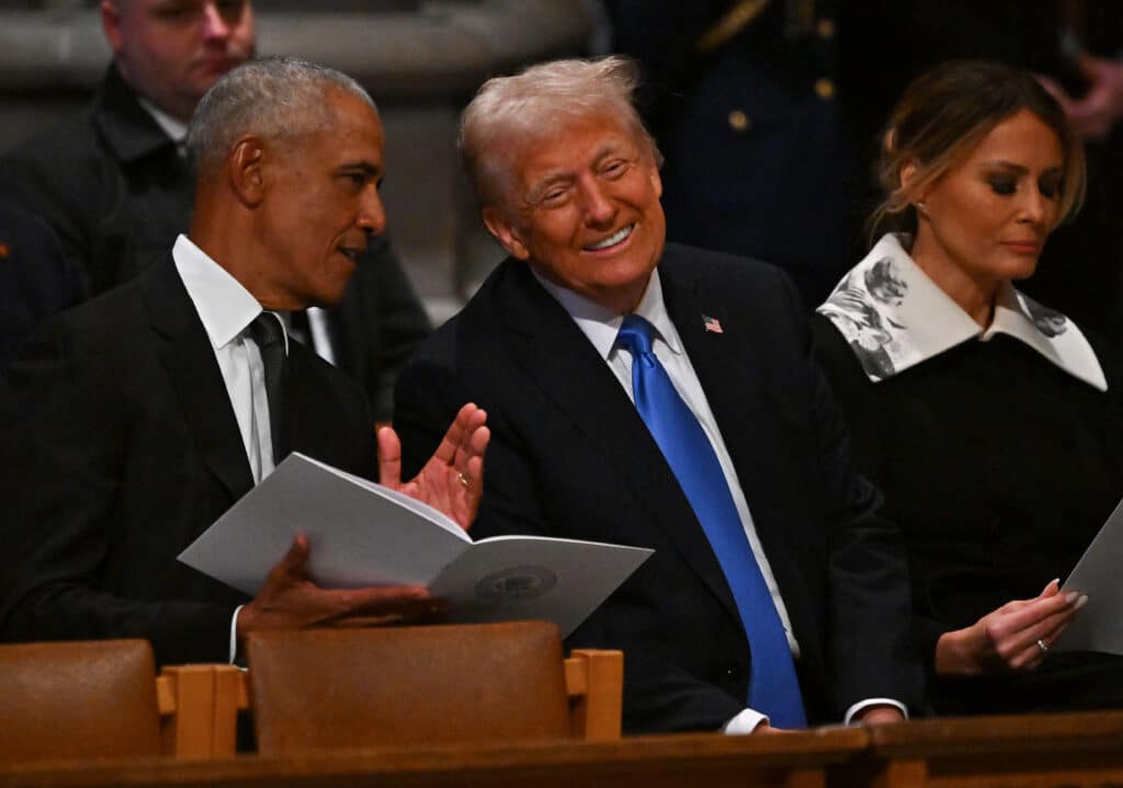 Former US President Barack Obama and President-elect Donald Trump speak ahead of the state funeral services for former President Carter at the National Cathedral on January 9, 2025 in Washington, DC. (Photo by Ricky Carioti / POOL / AFP)