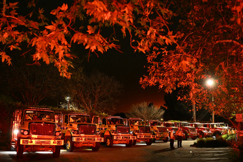 LAFD Wildland Fire Trucks line up by Mirman school near Mulholland drive as the Palisades Fire burns towards the Encino neighborhood in Los Angeles, California, January 10, 2025, triggering new evacuation orders. | Photo by Patrick T. Fallon / AFP