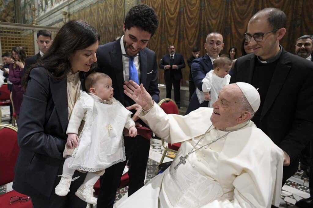 This handout photo taken and released on January 12, 2025, by Vatican Media, the Vatican press office, shows Pope Francis (R) carrying baptisms of infants as celebrates the mass for the Feast of the Baptism of the Lord in the Sistine Chapel, at the Vatican. | Photo by VATICAN MEDIA / AFP