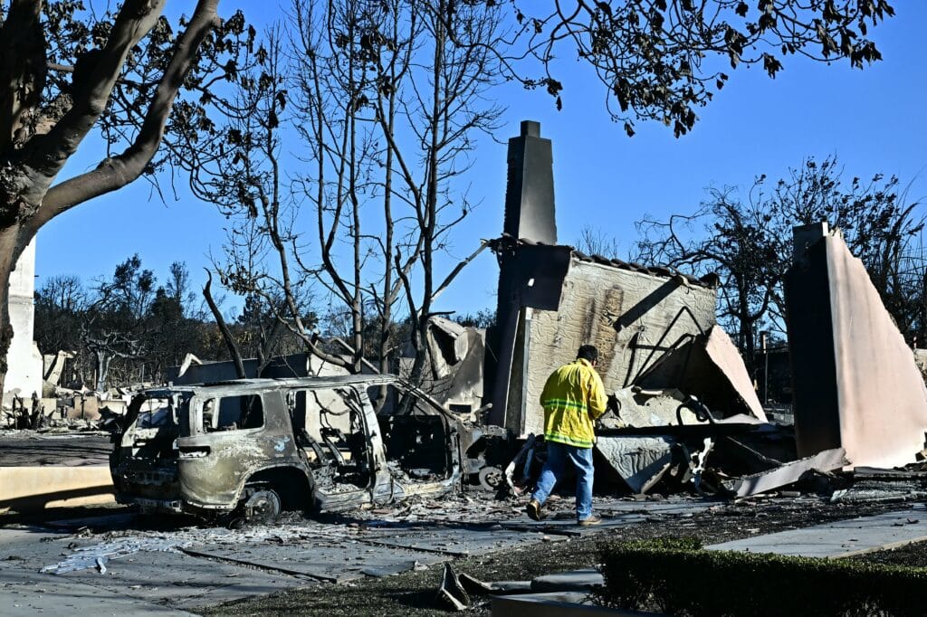 A burned-out car and home reduced to rubble by the Palisades Fire is seen in the Pacific Palisades neighborhood of Los Angeles, California, on January 12, 2025. US officials warned "dangerous and strong" winds were set to push deadly wildfires further through Los Angeles residential areas January 12 as firefighters struggled to make progress against the flames. | Photo by Frederic J. Brown / AFP