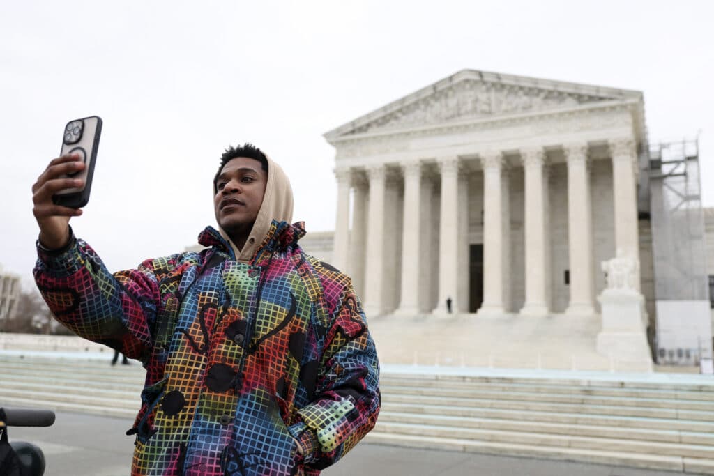 Jacob Smith records a video speaking about the Tik Tok ban and urging followers to follow him on other platforms outside of the U.S. Supreme Court on January 17, 2025 in Washington, D.C. The Supreme Court ruled that the social media platform Tik Tok must cut ties with ByteDance,its Chinese parent company, or cease its U.S. operations. | Kayla Bartkowski/Getty Images/AFP