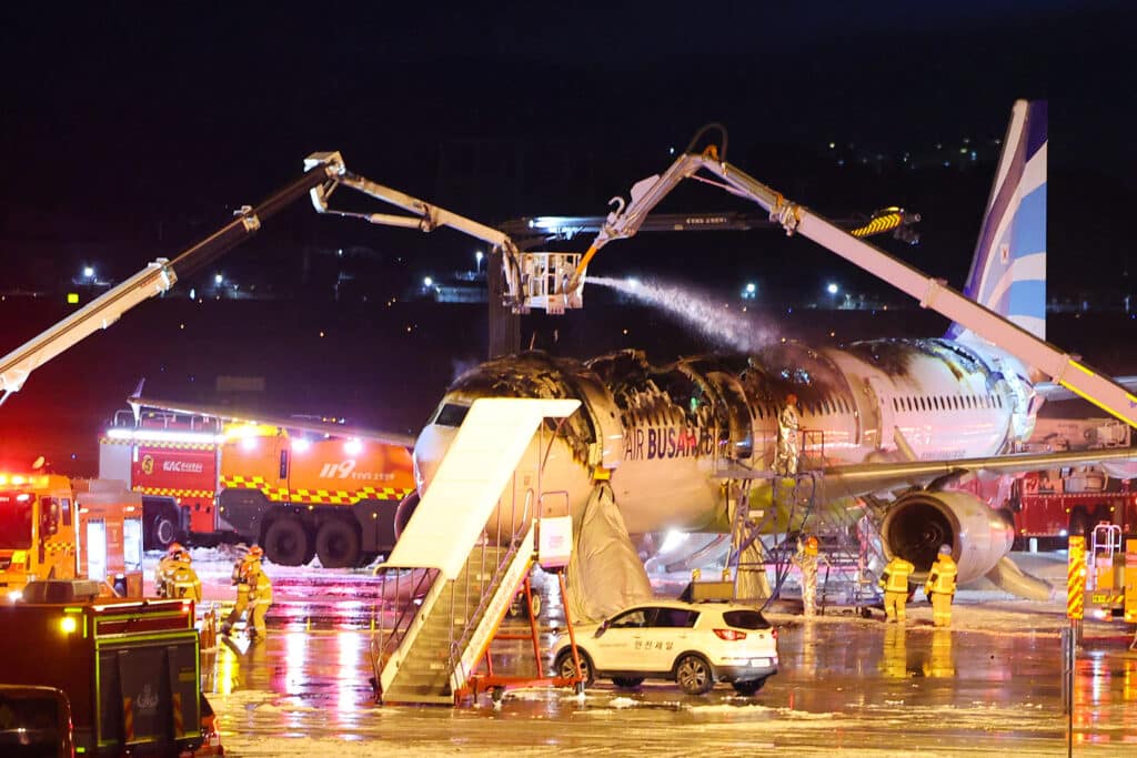 Firefighters make sure that the fire that broke out on an Air Busan passenger plane bound for Hong Kong are put out at Gimhae International Airport in Busan on January 28, 2025. | Photo by YONHAP / AFP)